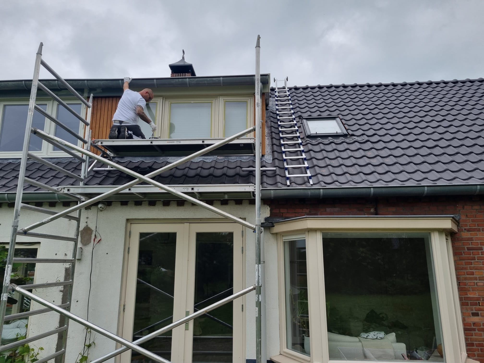 Van Leth Schilderwerken - Gevelmuur en kozijnen van een woning geschilderd in een strakke witte kleur, keurig afgewerkt.