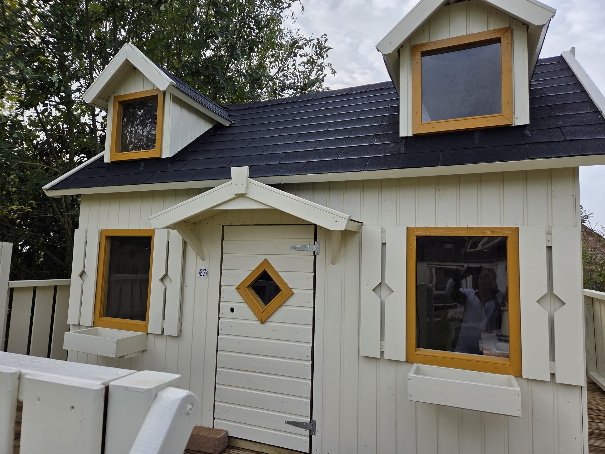 Van Leth Schilderwerken - Tuinhuis volledig opgefrist met een cremekleurige gevel en gele kozijnen. Buitenschilderwerk op maat.
